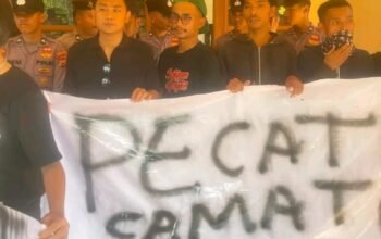 Massa aksi warga Saketi membawa spanduk bertuliskan tuntutan pencopotan camat dalam unjuk rasa di depan Kantor Kecamatan Saketi, Jumat 25 September 2025.