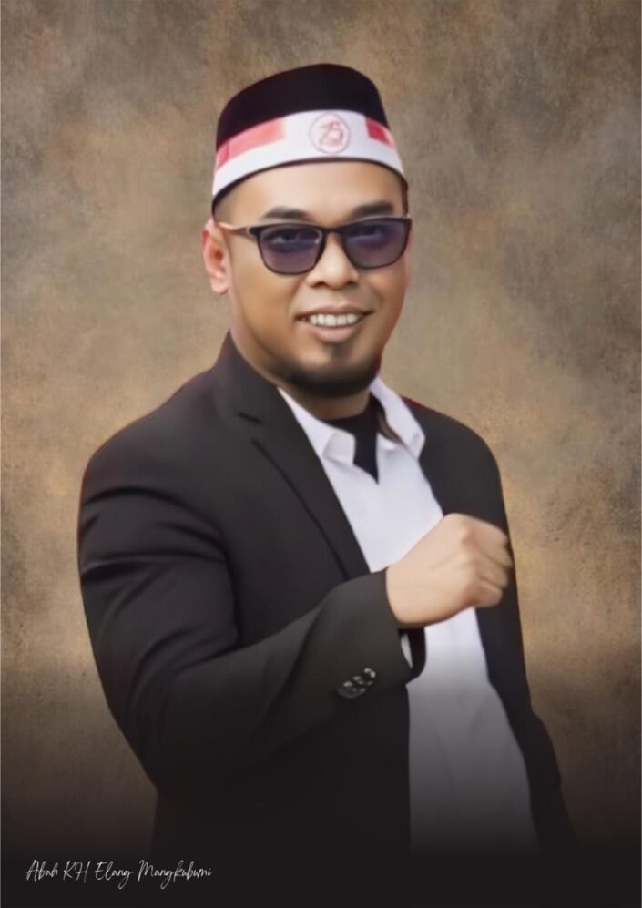 Abah Elang Mangkubumi mengenakan jas hitam dan peci khas Pagar Nusa, berpose dengan tangan mengepal sebagai simbol ketegasan dalam menolak proyek yang mengancam rakyat pesisir Serang.