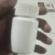 Botol plastik putih polos berisi kapsul herbal tanpa label.