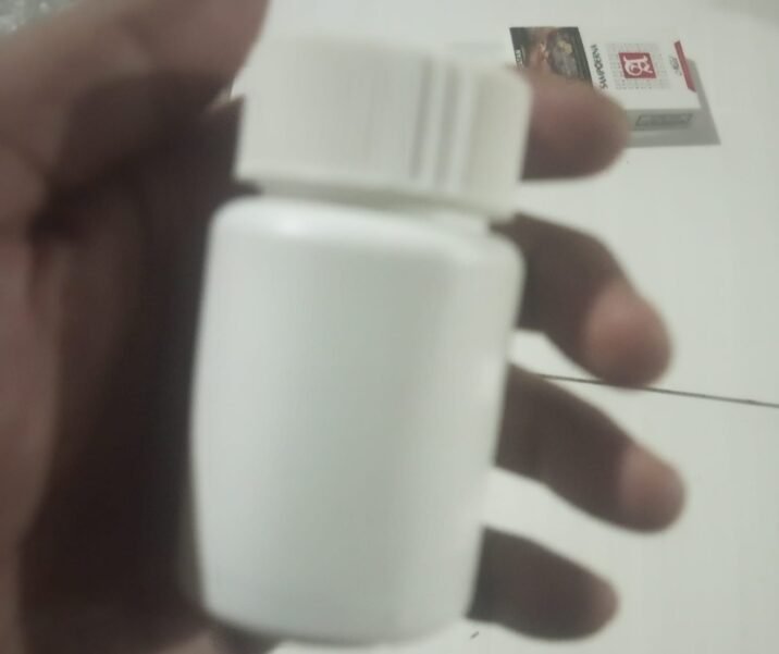 Botol plastik putih polos berisi kapsul herbal tanpa label.