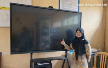 Kepala SDN 1 Cimenteng Jaya menunjukkan smart board sebagai sarana pembelajaran digital di ruang kelas