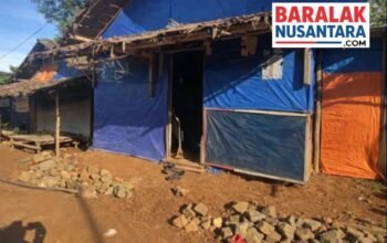 Hunian sementara (huntara) warga dengan dinding terpal biru dan oranye, berlatar kondisi lingkungan sederhana, dengan logo BaralakNusantara.com di pojok kanan atas.