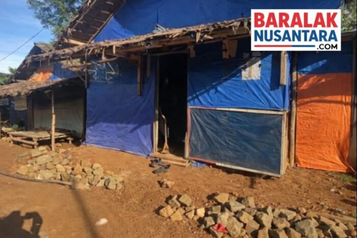 Hunian sementara (huntara) warga dengan dinding terpal biru dan oranye, berlatar kondisi lingkungan sederhana, dengan logo BaralakNusantara.com di pojok kanan atas.